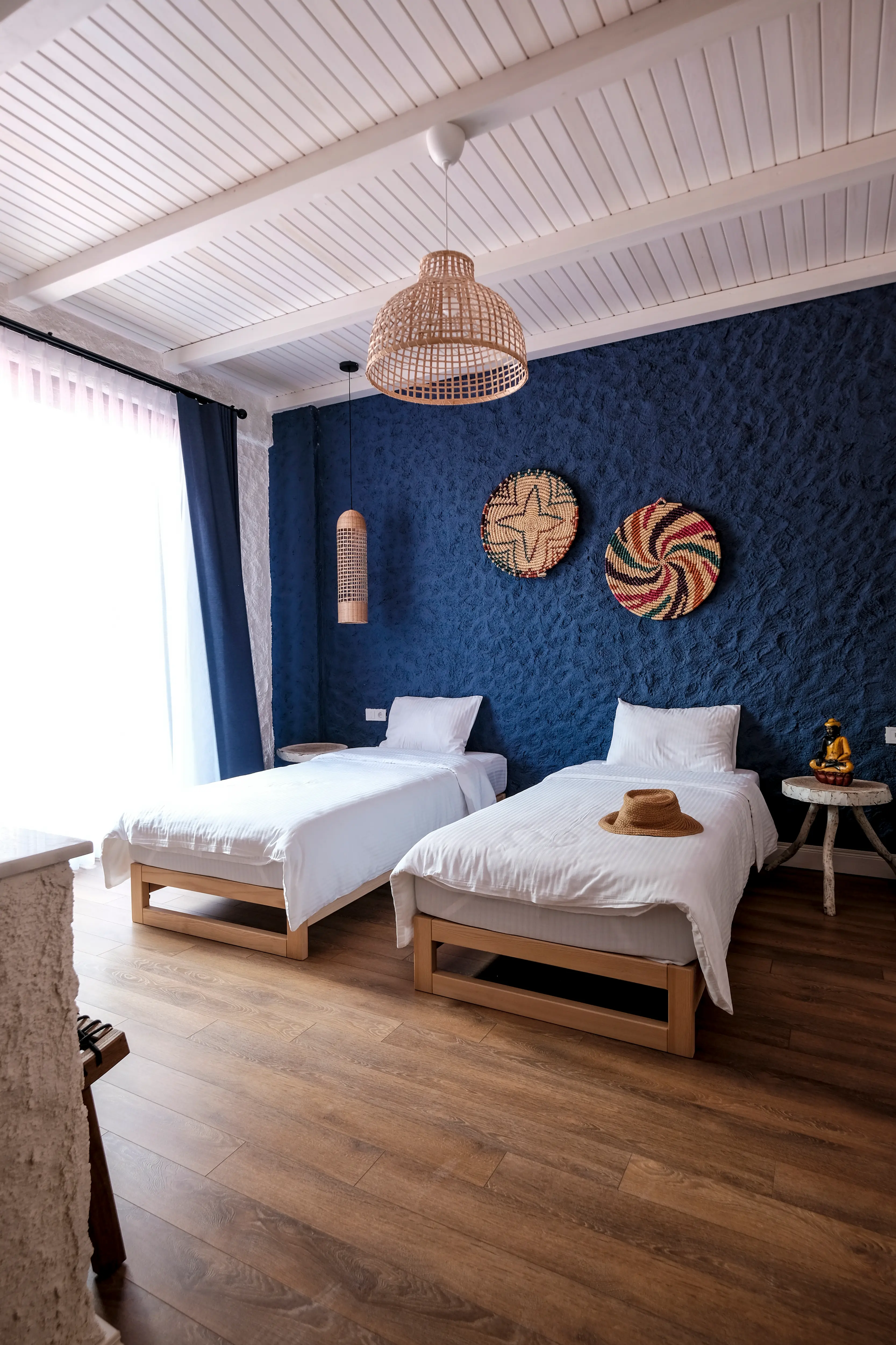Blue room with twin beds against a deep blue textured wall