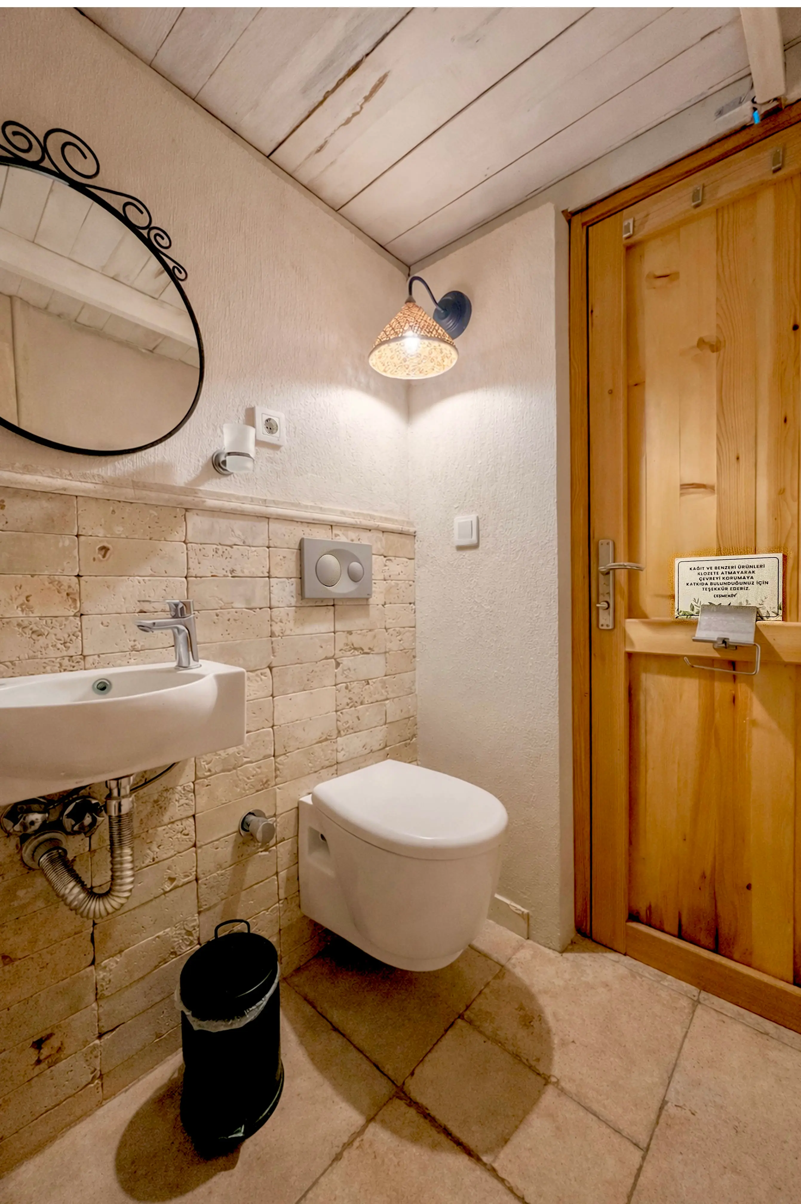 Private glamping bathroom with a sink, toilet and timber door