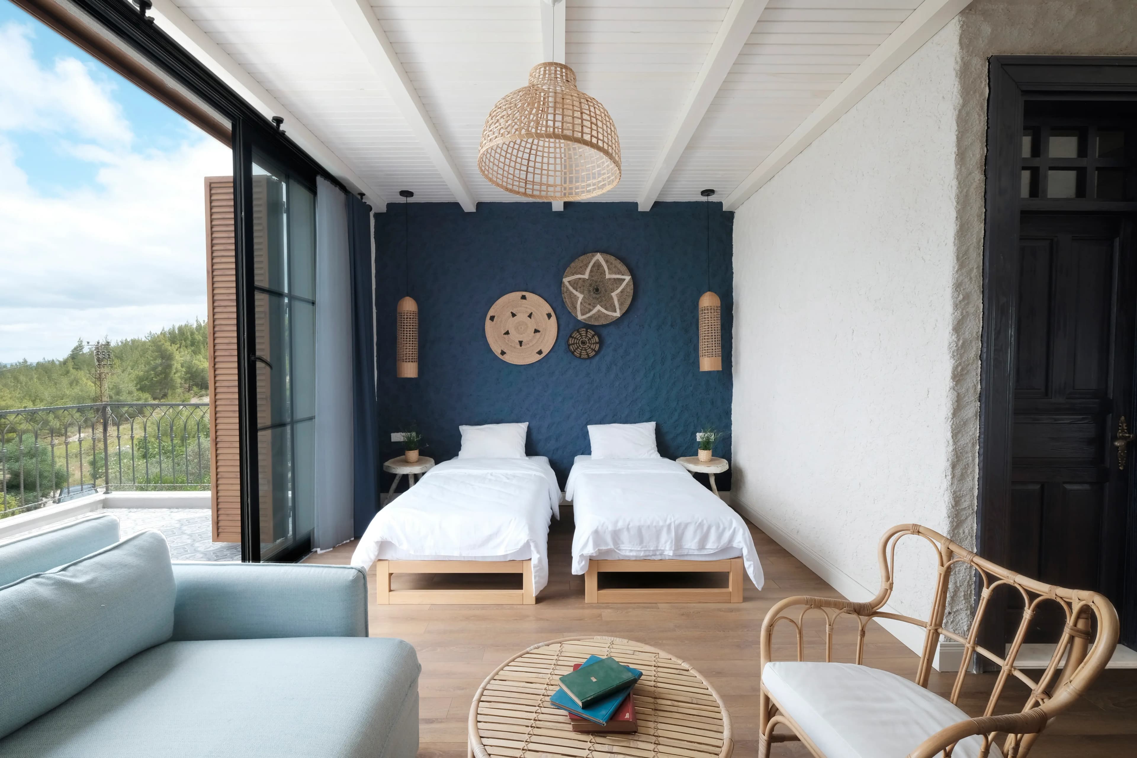 Terrace room with twin beds and a sofa, sliding door open to the terrace