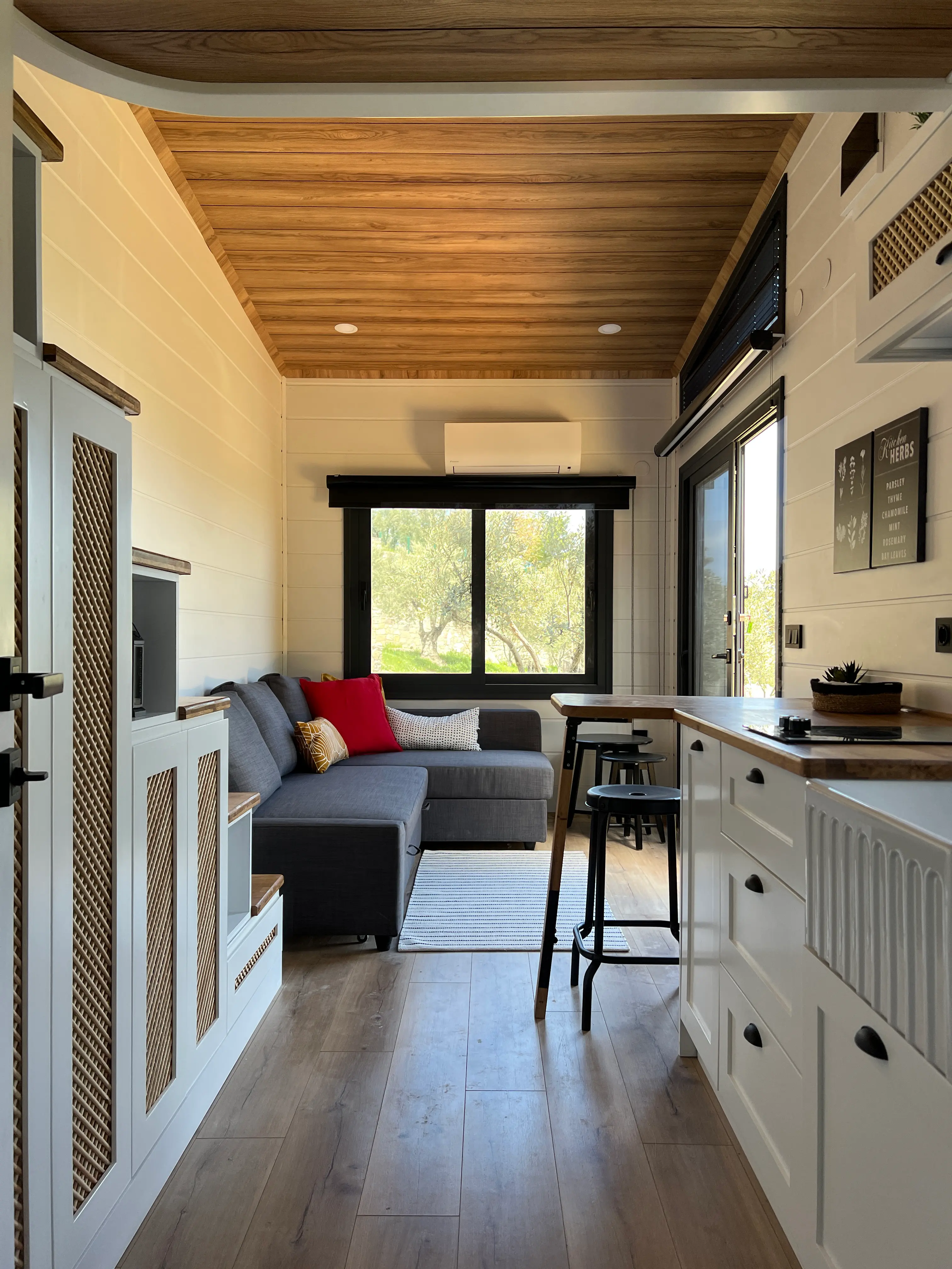 Tiny house living area with a sectional and kitchen counter